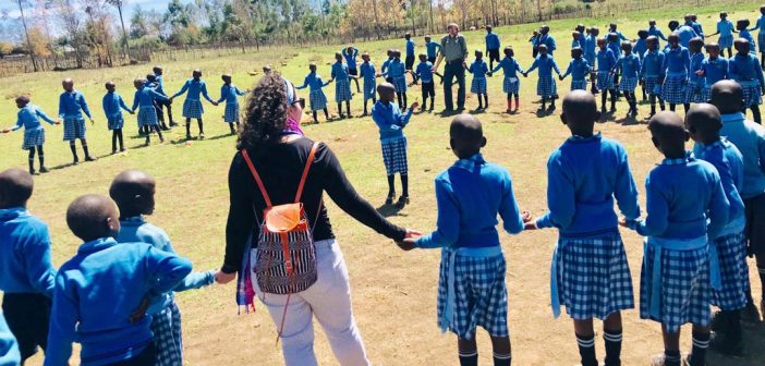 A large circle of children wearing blue uniforms