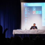 The silhouette of a man facing three panelists at a table