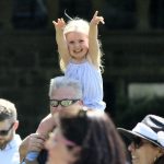 A child on someone's shoulders in the crowd.