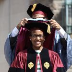 A graduate receiving a robe.