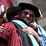 A graduate hugging former dean Virginia Roach.